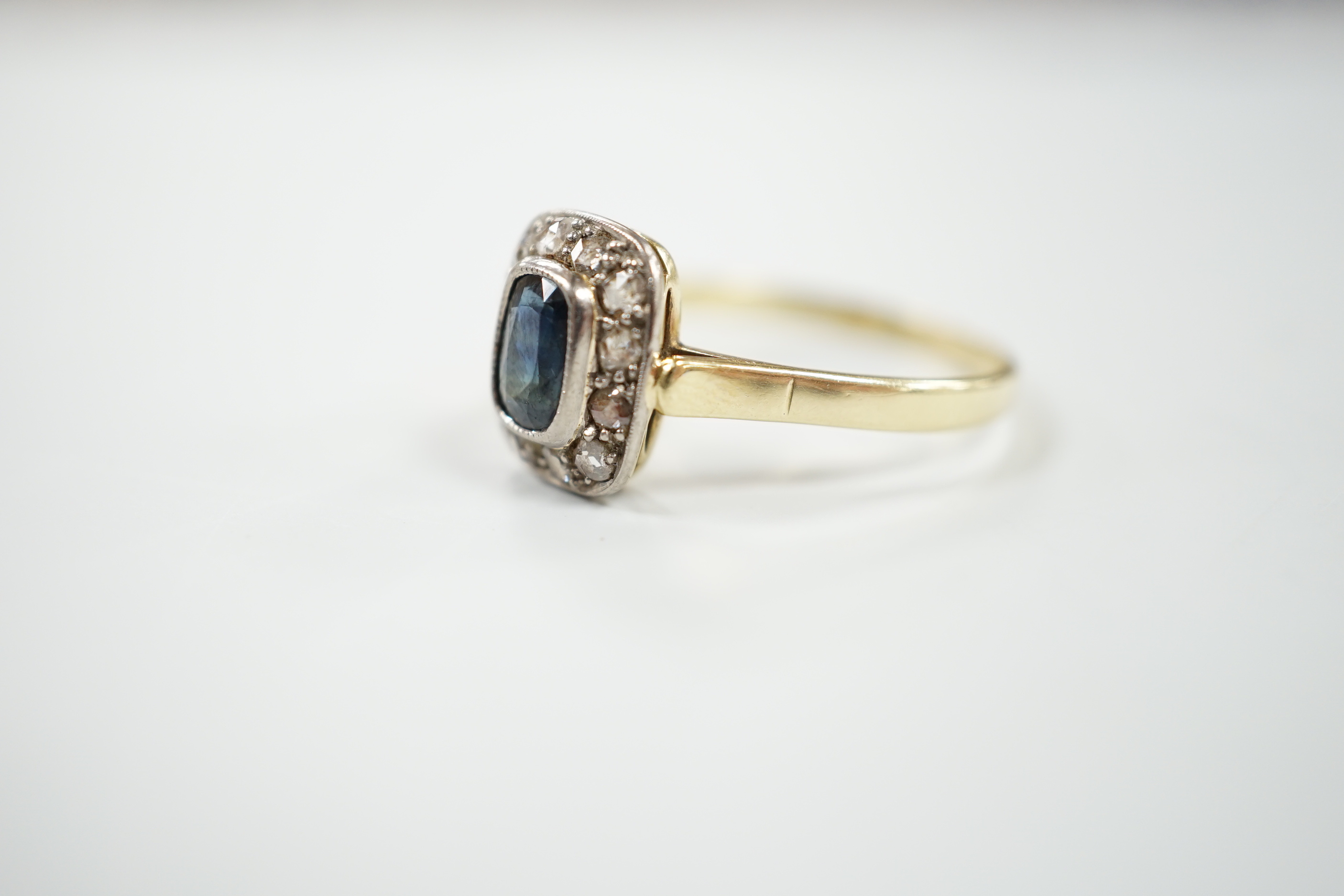A mid 20th century yellow metal, sapphire and diamond set rectangular cluster ring, size W/X, gross weight 3.7 grams.